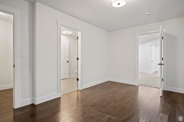 unfurnished room featuring dark wood-type flooring and baseboards