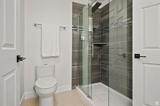 full bath featuring a stall shower, baseboards, and toilet