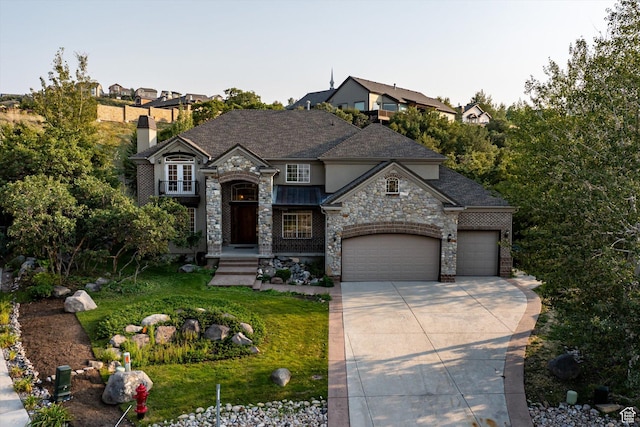 french country home with driveway, an attached garage, stone siding, and a chimney