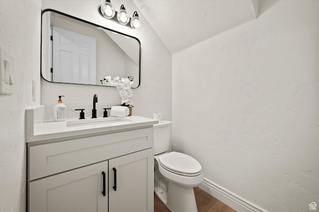 half bath with lofted ceiling, wood finished floors, toilet, and vanity