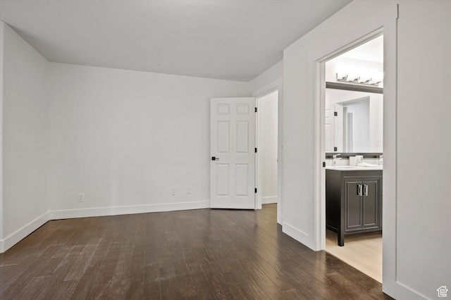 unfurnished room with baseboards and wood finished floors