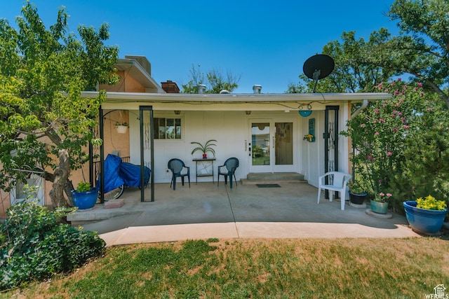 exterior space with a patio area, a chimney, and french doors