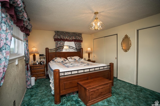 bedroom with dark carpet, a textured ceiling, and an inviting chandelier