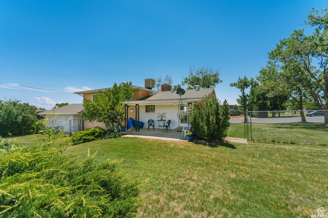 back of property featuring a patio, a lawn, fence, and central air condition unit