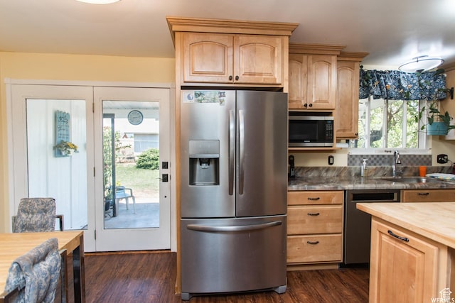 kitchen featuring stainless steel appliances, butcher block counters, dark wood-style flooring, a sink, and light brown cabinetry