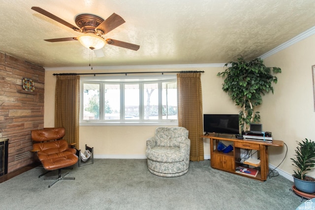 sitting room with a textured ceiling, a stone fireplace, carpet, and ornamental molding