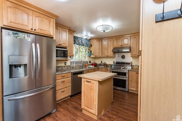 kitchen featuring butcher block counters, appliances with stainless steel finishes, dark wood-type flooring, light brown cabinetry, and under cabinet range hood