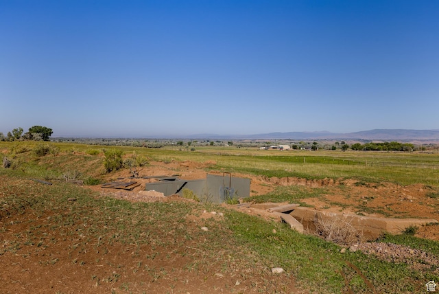 view of yard with a rural view and a mountain view