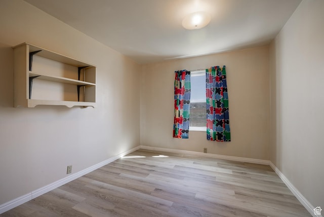 unfurnished room featuring baseboards and wood finished floors