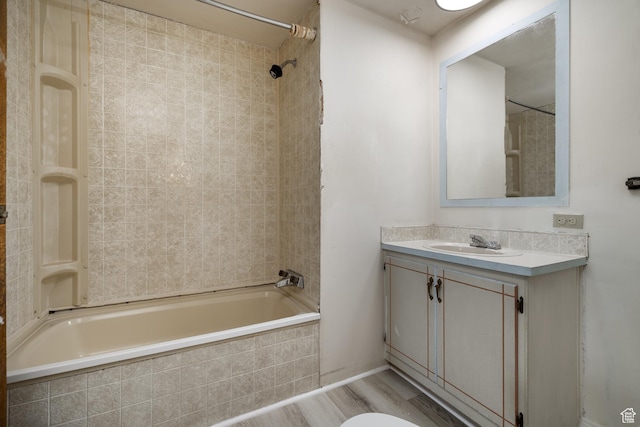 full bath with tiled shower / bath, wood finished floors, and vanity