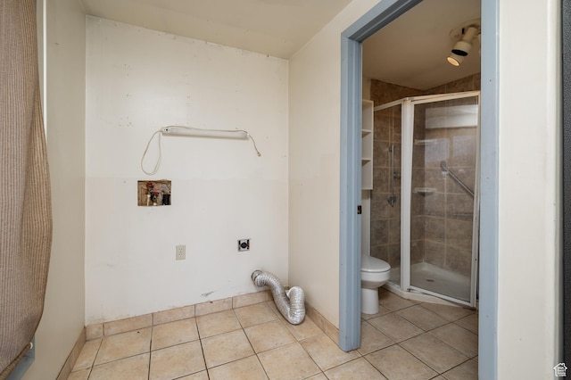 interior space with toilet, a stall shower, baseboards, and tile patterned floors