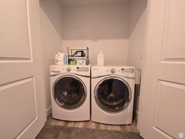laundry area featuring laundry area, wood finished floors, and washing machine and clothes dryer