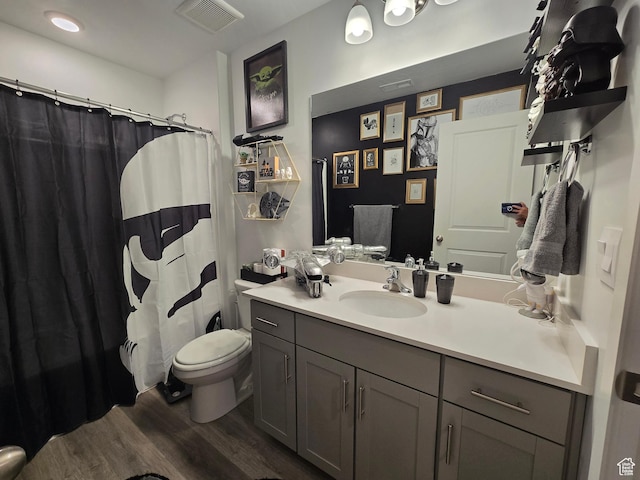 full bath with vanity, visible vents, toilet, wood finished floors, and a shower with shower curtain
