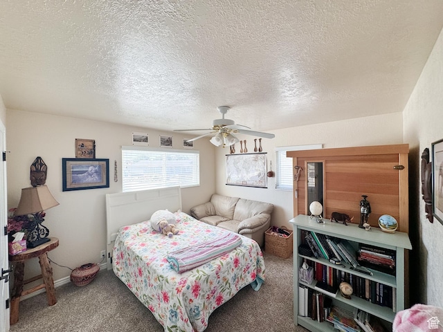 carpeted bedroom featuring a textured ceiling and a ceiling fan