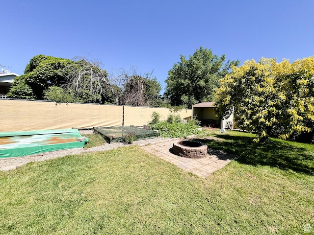 view of yard with a fire pit and fence