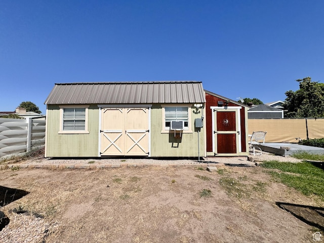 view of shed with cooling unit and fence