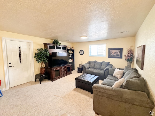 carpeted living room with visible vents and a textured ceiling
