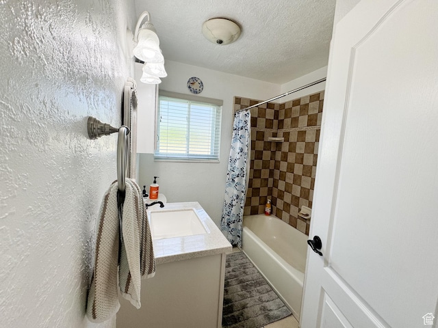 full bathroom featuring vanity, a textured ceiling, shower / tub combo, and a textured wall