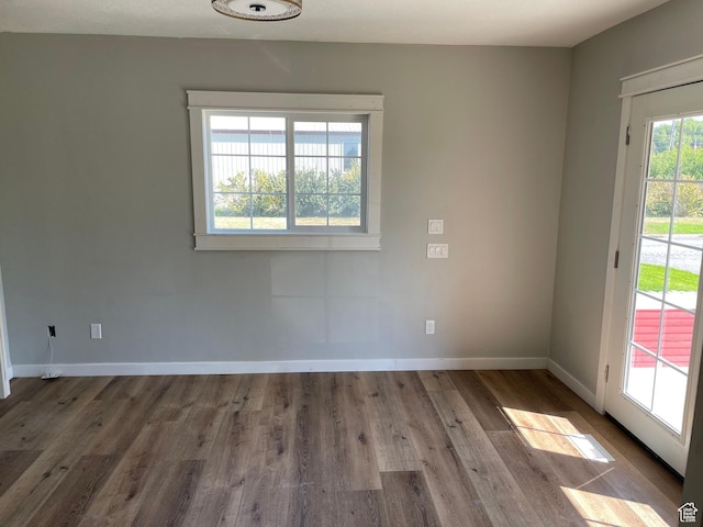 unfurnished room featuring baseboards and wood finished floors