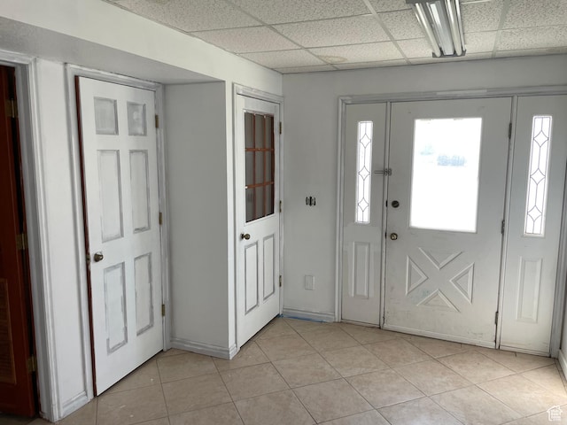 entryway featuring light tile patterned floors and a drop ceiling