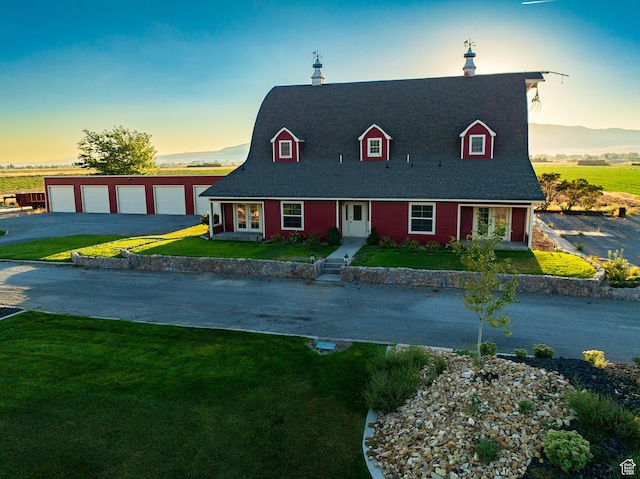 view of front of property featuring a shingled roof, a front yard, a garage, and french doors