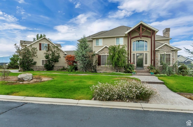 2118 S Centennial Blvd S, Saratoga Springs, UT 84045 - view of front of property with stucco siding, stone siding, a front lawn, and a chimney
