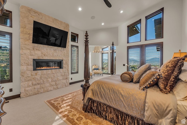 bedroom with baseboards, carpet flooring, multiple windows, and a fireplace