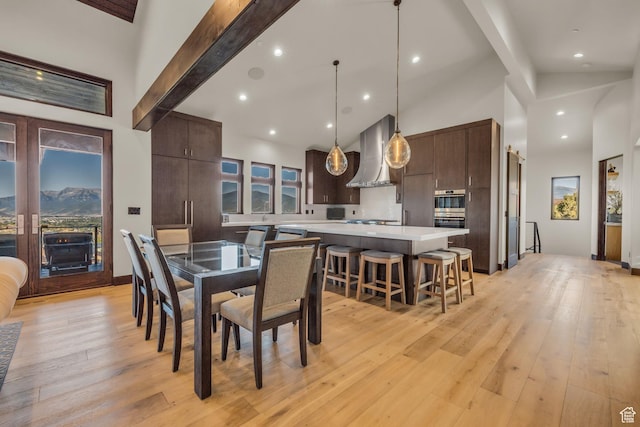dining area with light wood finished floors, beam ceiling, high vaulted ceiling, and recessed lighting
