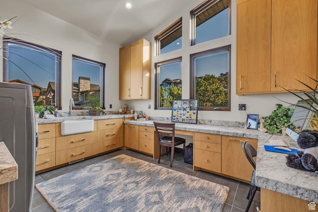 kitchen featuring light countertops, built in study area, and a sink