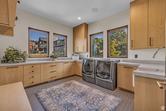washroom featuring recessed lighting, tile patterned flooring, a sink, washing machine and clothes dryer, and cabinet space