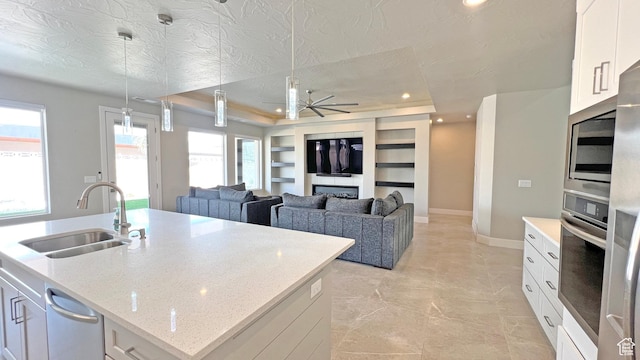 5178 W 2150 S, Hurricane, UT 84737 - kitchen with a sink, ceiling fan, appliances with stainless steel finishes, built in shelves, and an island with sink