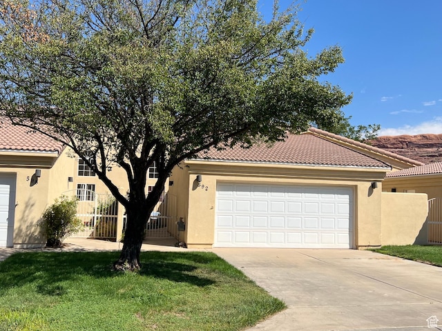 592 W Hale Ave, Moab, UT 84532 - mediterranean / spanish home featuring stucco siding, driveway, a tile roof, and a garage