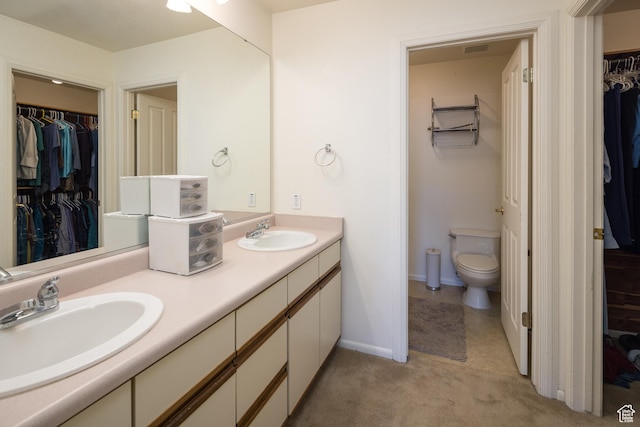 592 W Hale Ave, Moab, UT 84532 - bathroom featuring toilet, double vanity, a spacious closet, and baseboards