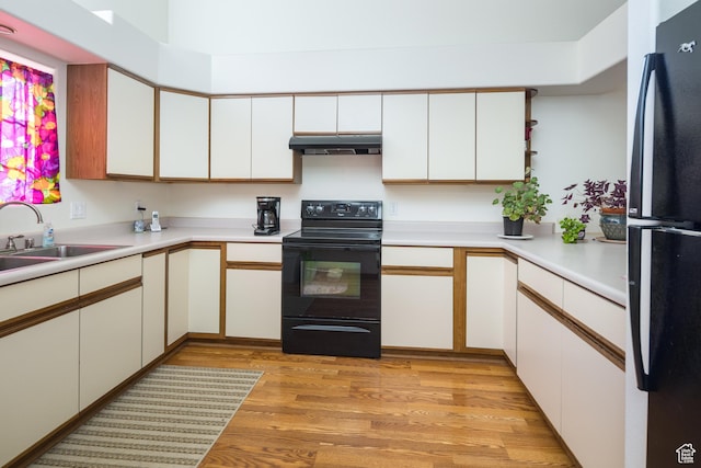 592 W Hale Ave, Moab, UT 84532 - kitchen featuring black appliances, under cabinet range hood, a sink, light countertops, and light wood-style floors