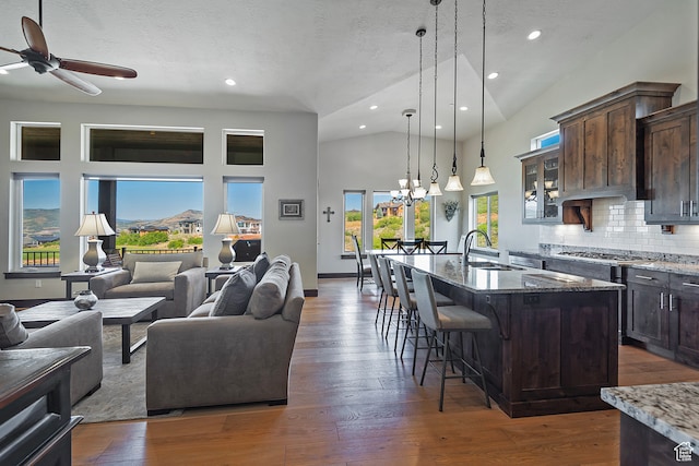 1375 E Lasso Trl, Hideout, UT 84036 - kitchen with ceiling fan with notable chandelier, a center island with sink, dark wood-type flooring, sink, and dark stone counters