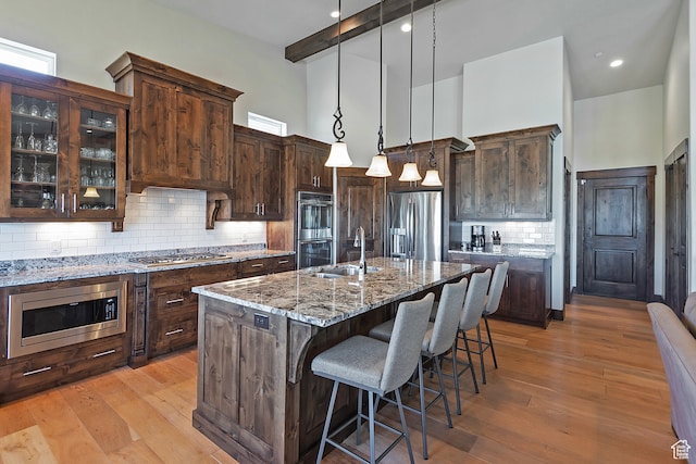 1375 E Lasso Trl, Hideout, UT 84036 - kitchen featuring dark brown cabinets, stainless steel appliances, sink, a towering ceiling, and light wood-type flooring
