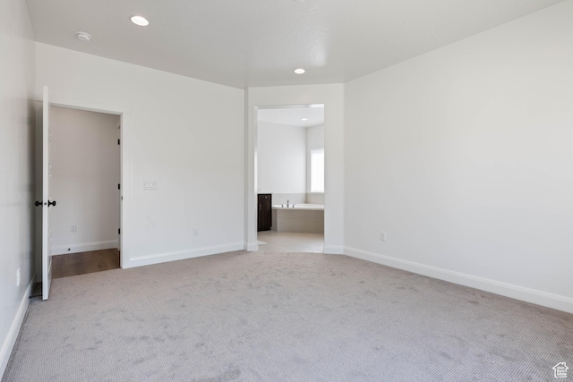 unfurnished bedroom with connected bathroom, baseboards, carpet floors, and recessed lighting