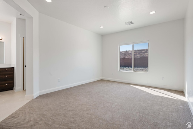 empty room with recessed lighting, baseboards, visible vents, and light colored carpet