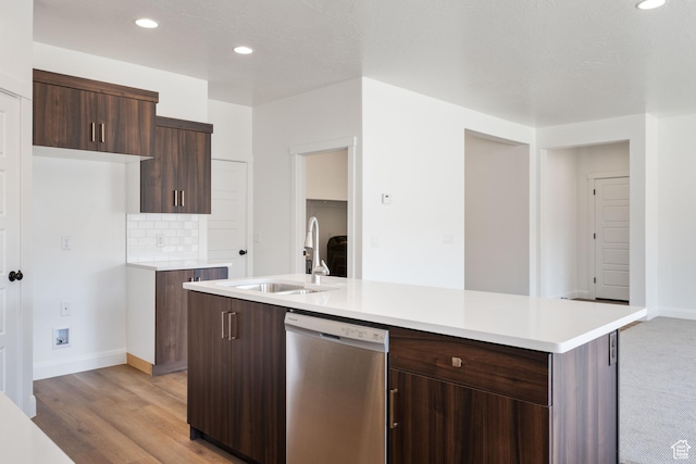 kitchen with baseboards, dishwasher, light countertops, and a sink