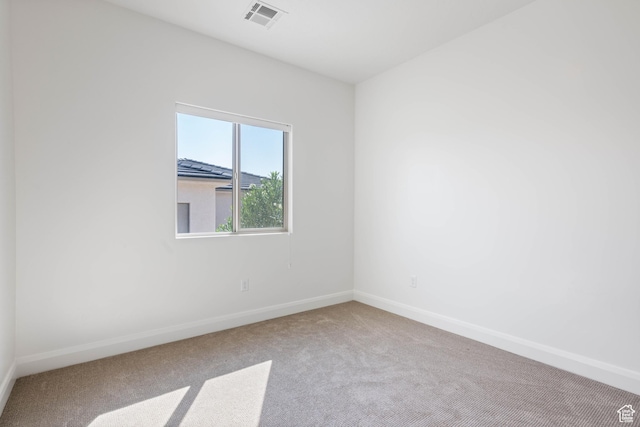 carpeted empty room featuring baseboards and visible vents