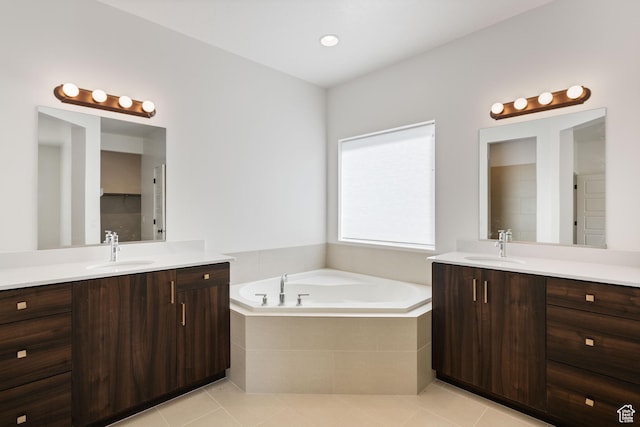 bathroom with two vanities, a bath, a sink, and tile patterned flooring