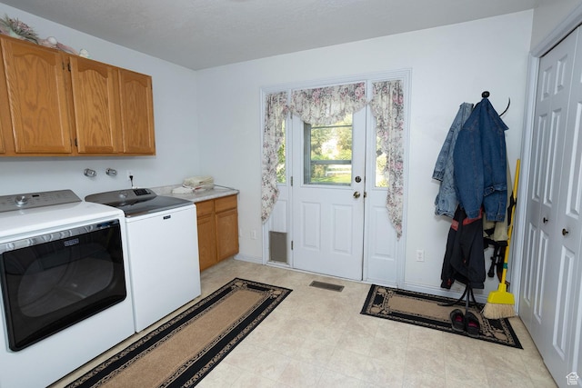 laundry area featuring light floors, independent washer and dryer, cabinet space, and visible vents