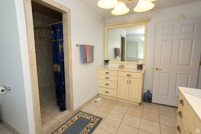 full bath with visible vents, a tile shower, vanity, tile patterned floors, and an inviting chandelier