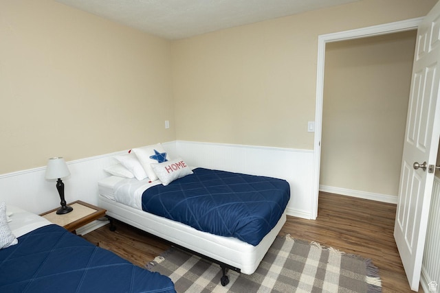 566 S Main St, Lyman, UT 84749 - bedroom featuring a wainscoted wall and wood finished floors