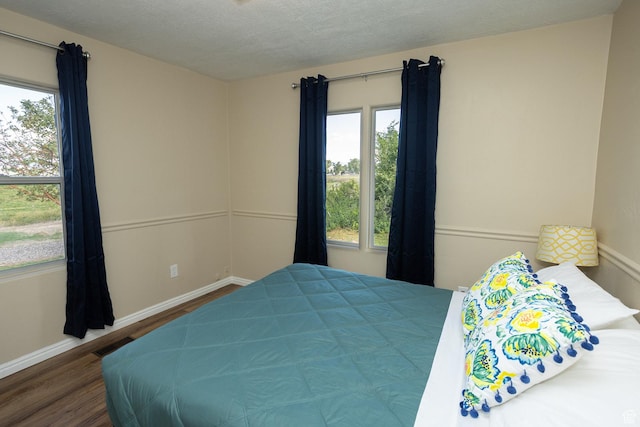 566 S Main St, Lyman, UT 84749 - bedroom featuring wood finished floors, multiple windows, baseboards, and a textured ceiling