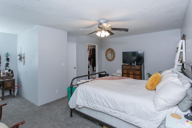 carpeted bedroom featuring a closet, a textured ceiling, a spacious closet, and a ceiling fan