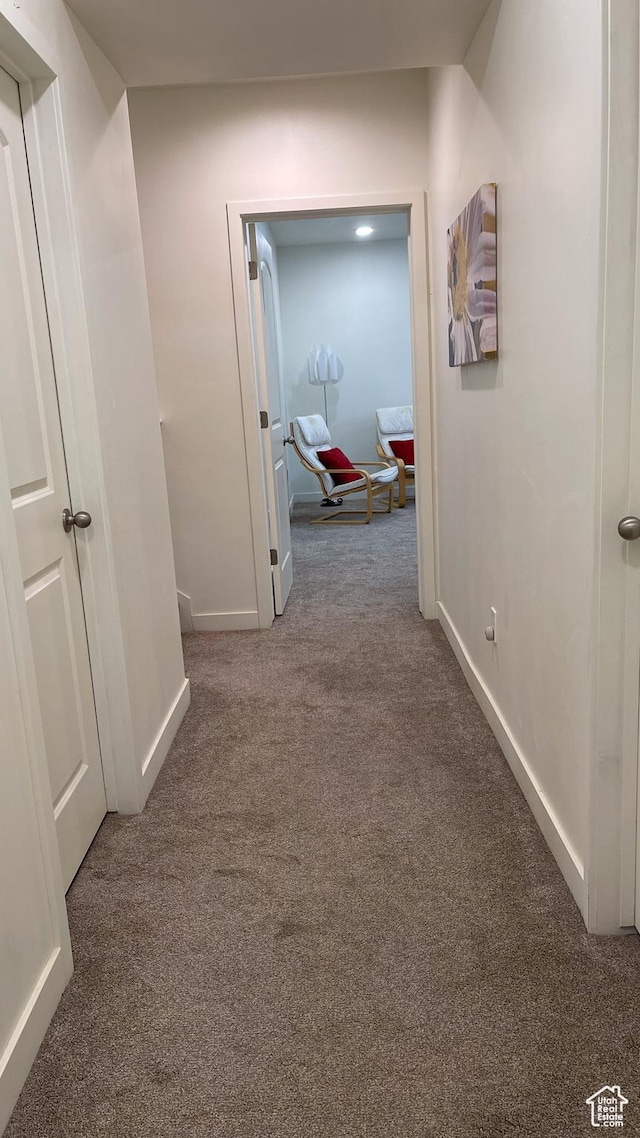 hall featuring carpet floors and baseboards