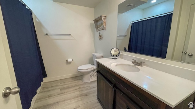 full bathroom featuring wood finished floors, visible vents, toilet, vanity, and baseboards