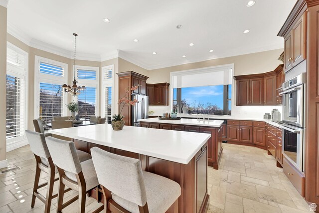 5210 Skyline Pkwy, Ogden, UT 84403 - kitchen featuring stone tile floors, a kitchen island, appliances with stainless steel finishes, visible vents, and ornamental molding