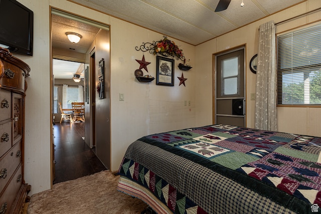 bedroom with ceiling fan, ornamental molding, dark hardwood / wood-style flooring, and a textured ceiling